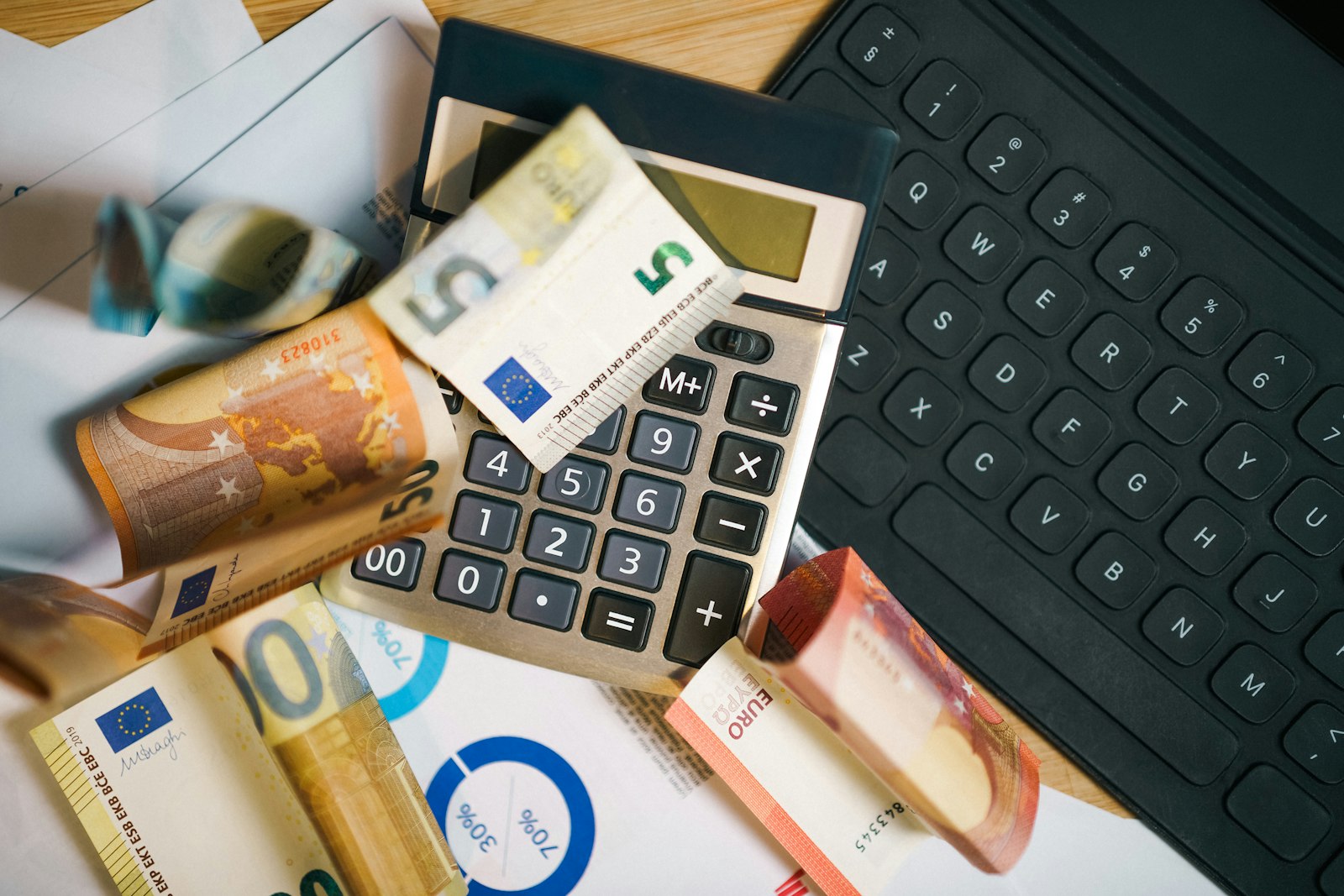 Calculadora sobre pilha de dinheiro, representando controle de faturamento do MEI