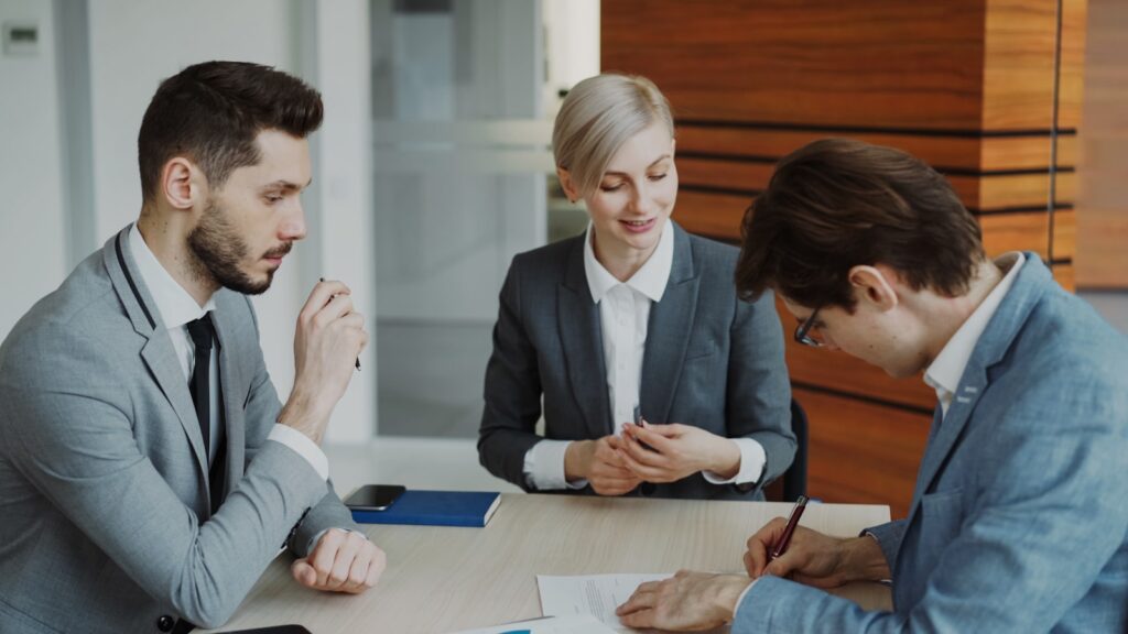 Pessoas assinando contrato de abertura de empresa em escritório