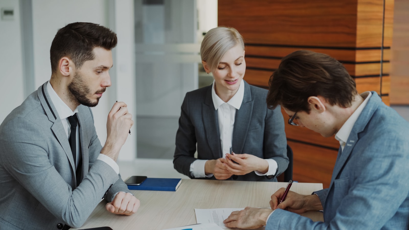 Pessoas assinando contrato de abertura de empresa em escritório