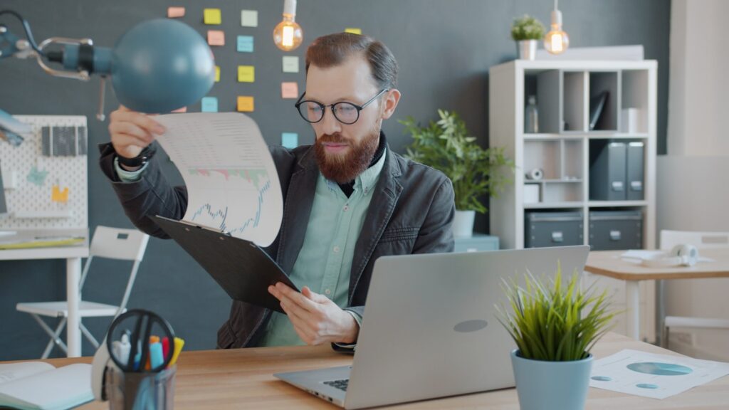 Profissional analisando gráficos e documentos para decidir entre Lucro Presumido e Simples Nacional