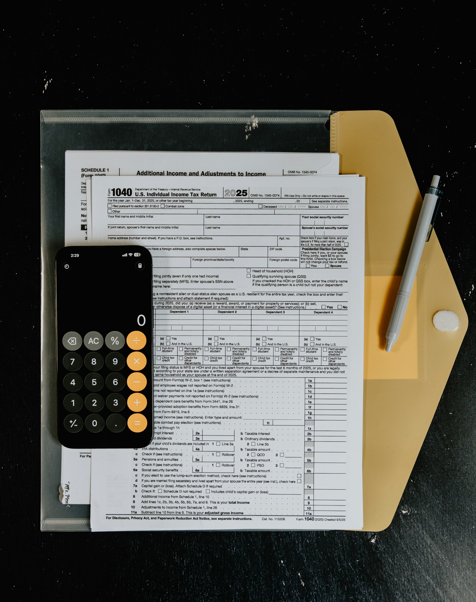 Formulários de imposto, calculadora e caneta sobre mesa, representando a retenção de impostos na nota fiscal de serviço
