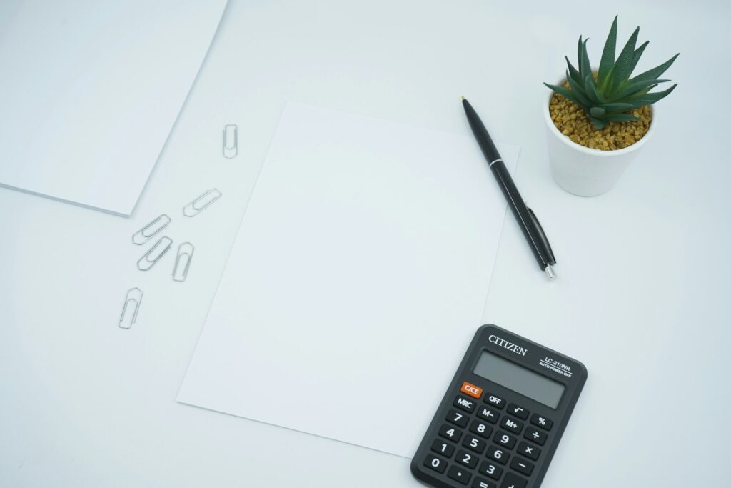 Calculadora e papel em branco representando o cálculo do regime de caixa ou competência para PJ