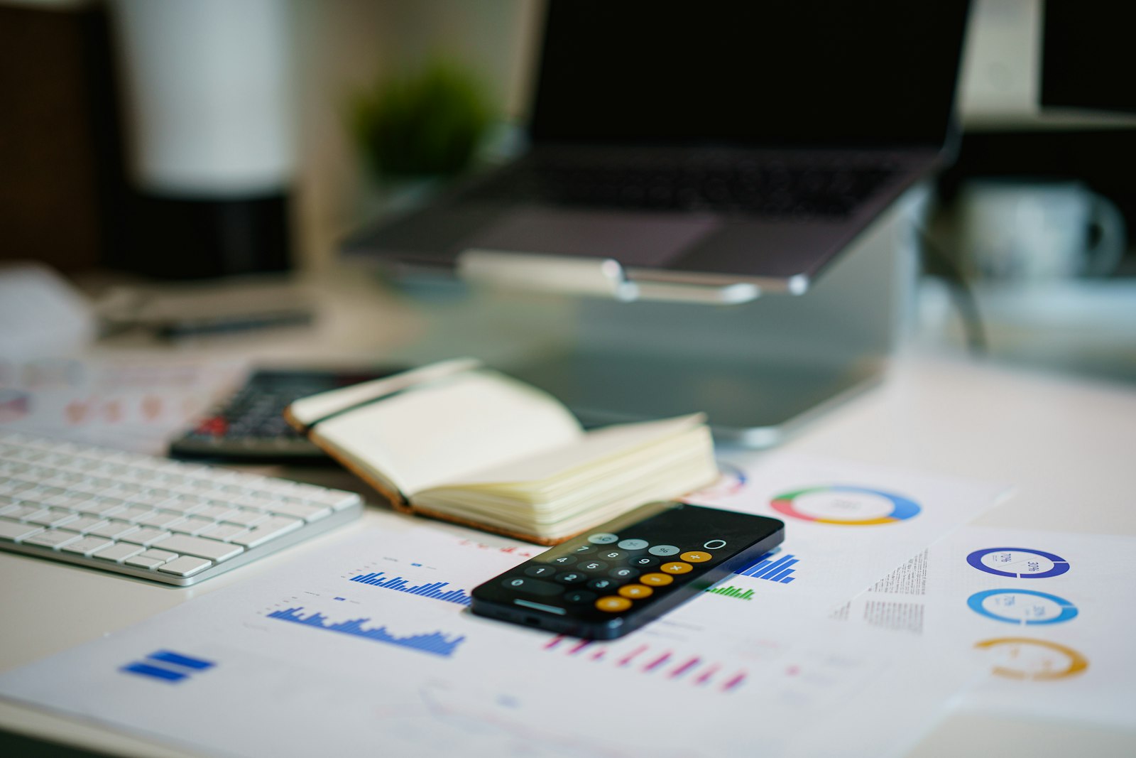 Reinvestimento de lucros na PJ: mesa de escritório com calculadora e gráficos financeiros representando o planejamento entre pró-labore e dividendos
