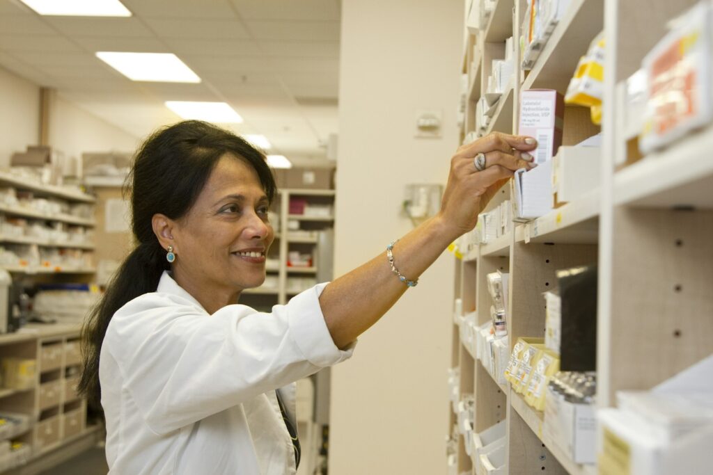 Farmacêutica organizando medicamentos, representando a contabilidade para farmacêuticos com CNPJ